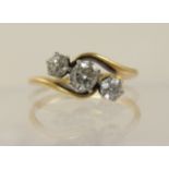 An 18ct three stone diamond ring the three diamonds are set in classic crown settings on a twist,