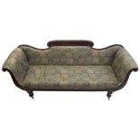 A George IV mahogany scroll end settee with acanthus leaf and scroll decoration on faceted