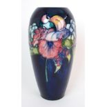 A Moorcroft Pottery "Orchid" vase baluster-form with orchids circumventing body on blue ground,