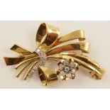 A vintage diamond brooch  set in yellow metal with a diamond set flower and ribbon to an approximate