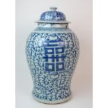 A Chinese blue and white tea jar painted with calligraphy and scrolling foliage, the domed cover and
