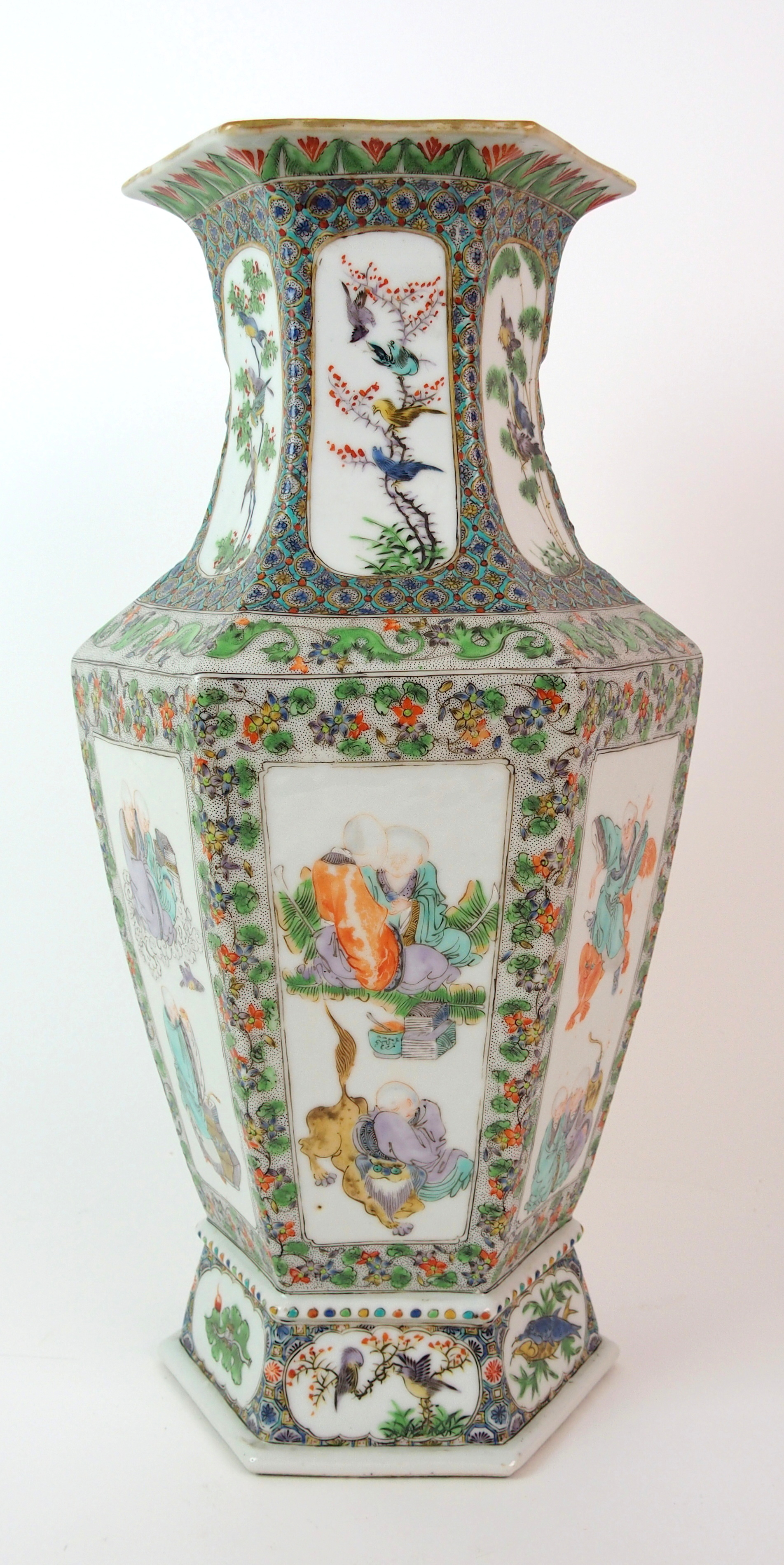 A Cantonese hexagonal tapering vase painted with panels of immortals within foliate and seed
