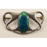 A silver Art Nouveau enamelled brooch of classic interlaced design with an oval panel enamelled in