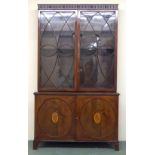 A mahogany library bookcase with a pair of astragal doors enclosing three shelves, the base with two