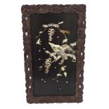 A Japanese lacquered and inlaid mother of pearl wall panel depicting a bird of prey and wisteria,