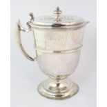 A hammered silver jug by George Fox, London 1907, of tapering cylindrical shape, the hinged lid with