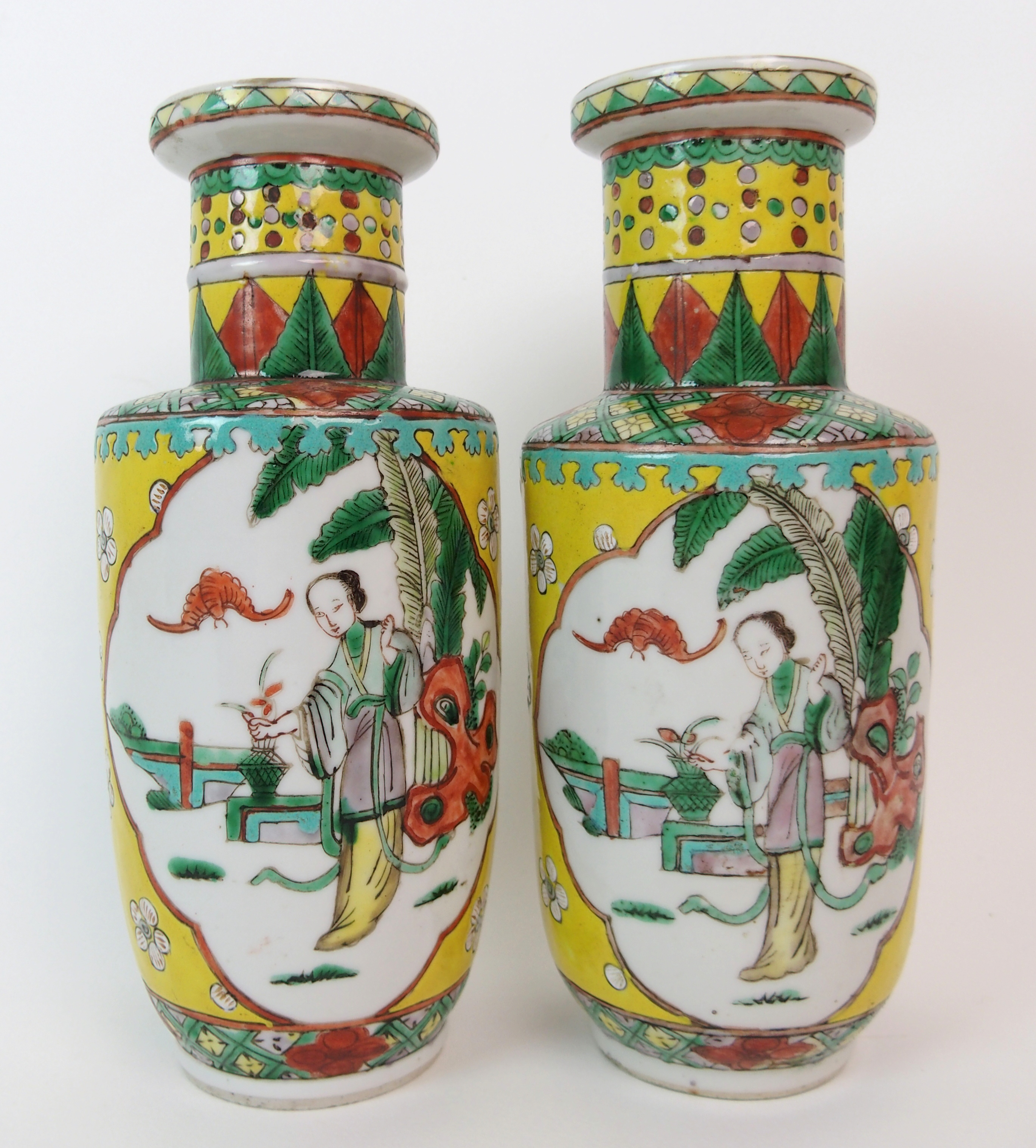 A pair of Chinese famille verte vases on a yellow ground, painted with panels of figures in ogival