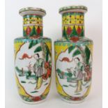 A pair of Chinese famille verte vases on a yellow ground, painted with panels of figures in ogival