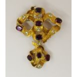 A Victorian bow brooch set with foiled back garnets and pale yellow gemstones onto ribbons of