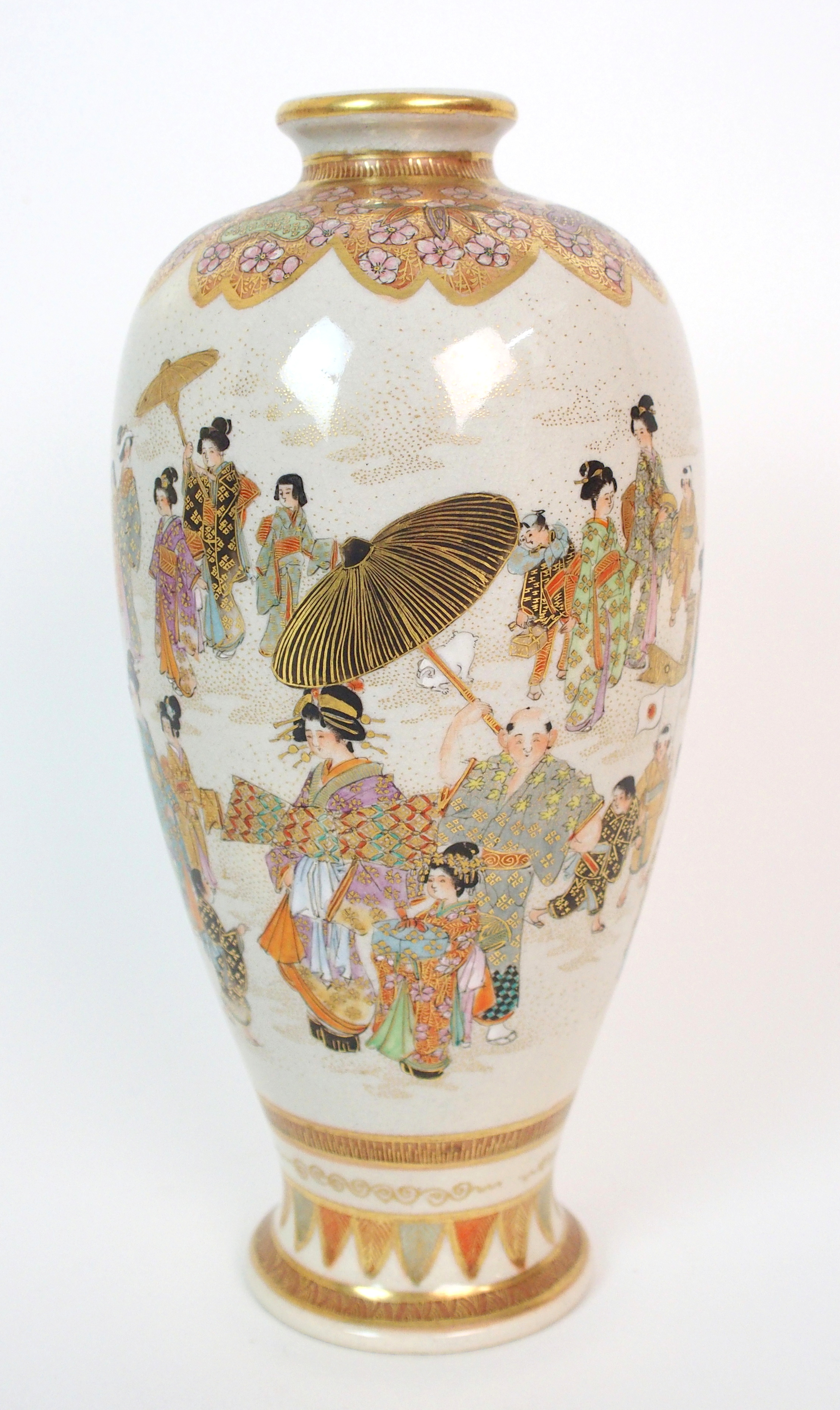 A Satsuma vase painted with numerous figures beneath a gilt foliate shoulder and above a stiff