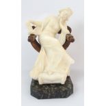 An Italian carved alabaster figural sculpture figure depicting a draped woman resting in a wood