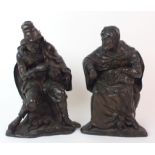 A pair of patinated cast bronze figures one depicting a seated man playing an instrument with a