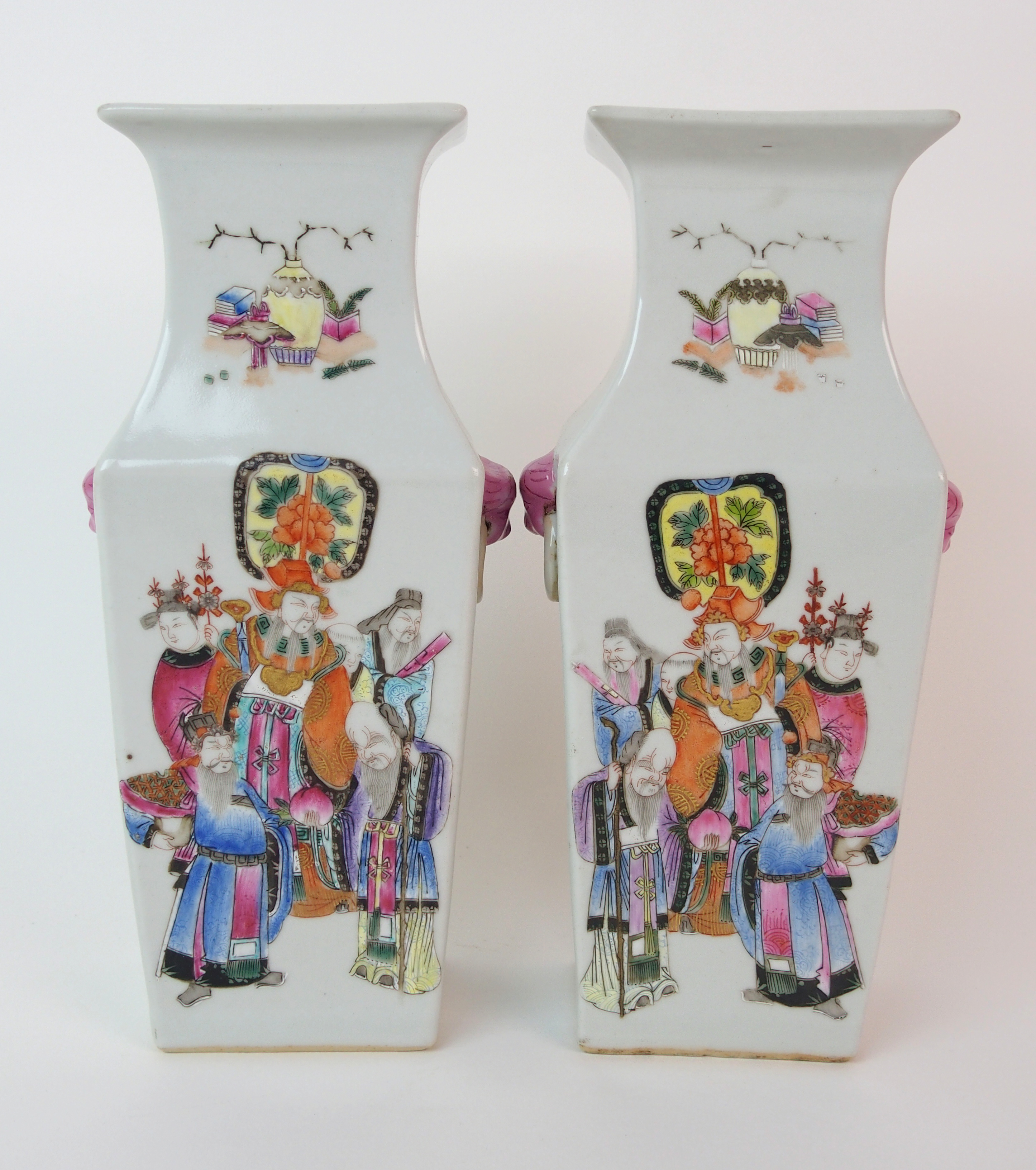 A pair of Canton famille rose square baluster vases painted with mandarins and courtesans divided by