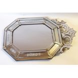 An Italian octagonal wall mirror with foliate scrolling surmount above faceted and acid etched
