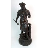 A patinated cast spelter figure  circa 1900, modelled as a blacksmith at work, raised on a socle