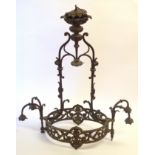 An Edwardian brass electrolier cast with pierced foliage, the oval frame supporting two pairs of