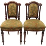 A set of six Victorian mahogany dining chairs with carved rails, padded backs and seats, on fluted