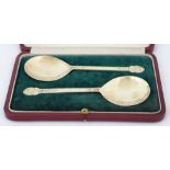 A cased pair of silver gilt serving spoons by Wilson & Sharp, Edinburgh 1919, the shallow circular