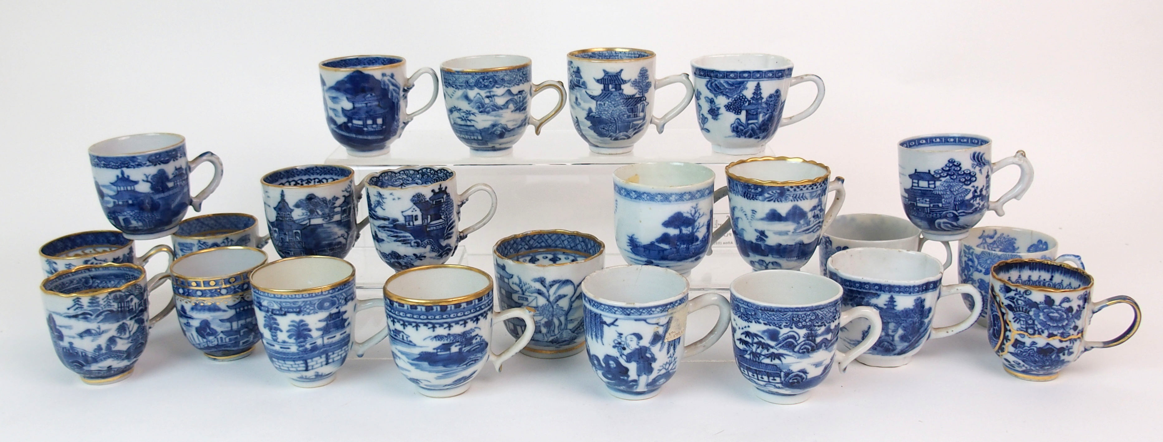 A group of twenty-three Chinese export teacups painted with typical landscapes and gilt rims,