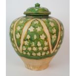 A sancai-glazed baluster jar and cover with triangular floral pattern panels in green and yellow (