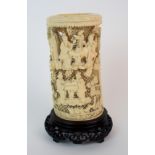 A Cantonese ivory tusk pierced and carved with figures at tables eating amongst pavilions and pine