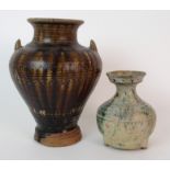 A Chinese treacle glaze baluster vase incised with geometric bands with lug handles to shoulder (