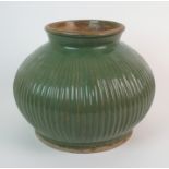 A Chinese celadon ribbed oviform vase with broad everted neck above a raised circular foot rim, 23cm