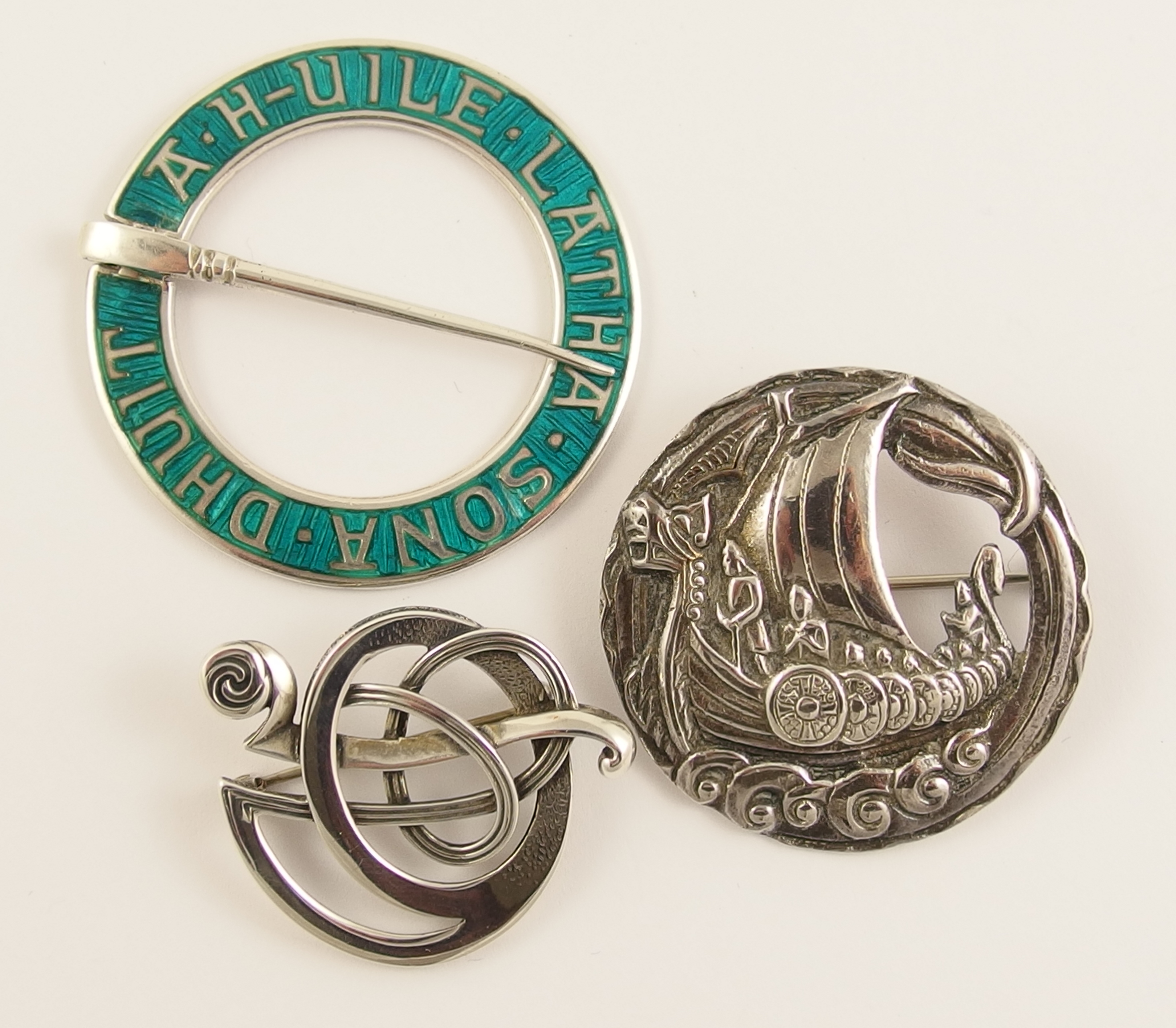 Three Scottish brooches a silver and turquoise green enamel annular brooch designed by Alexander
