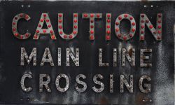 CAUTION MAIN  LINE CROSSING Notice with alloy letters on a flanged steel backing. The first word has