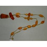 An amber bead necklace and pendant, desi