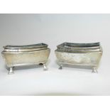 A pair of rectangular silver salts, hallmarked Birmingham 1912, each raised on four outswept feet