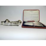 A cased set of six silver handled side knives hallmarked Sheffield together with five silver napkin