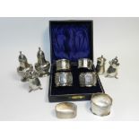 A collection of six silver napkin rings, together with a pair of silver pepper shakers hallmarked