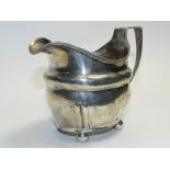 A Georgian silver cream jug, maker's mark WW, of oval form with reeded rim and handle and raised on