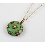 A 19th century enamel and seed pearl mourning locket with chain, the green enamel circular locket