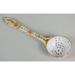 A French porcelain sugar sifter spoon, possibly late 18th century, the plain white spoon decorated