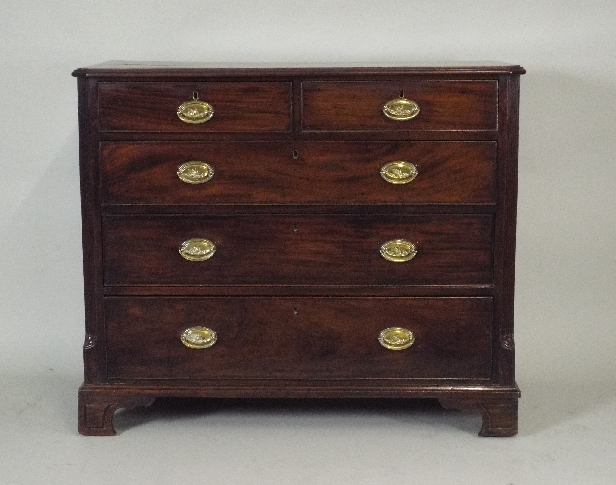 A George III mahogany chest of two short over three long graduated  cockbeaded drawers fitted with