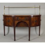 A George III mahogany bowfront sideboard the brass rail back over a central short frieze drawer