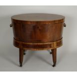 A George III mahogany rosewood crossbanded wine cooler of oval form the hinged lid opening to