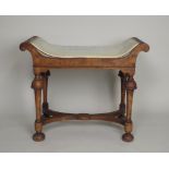 A 1920s William and Mary style walnut dressing stool, the dished seat on four inverted cup and