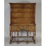 A George I style walnut chest on stand, the crossbanded and quarter veneered top over two short and