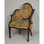 An Edwardian mahogany boxwood line strung enclosed armchair, the oval padded back between sweeping