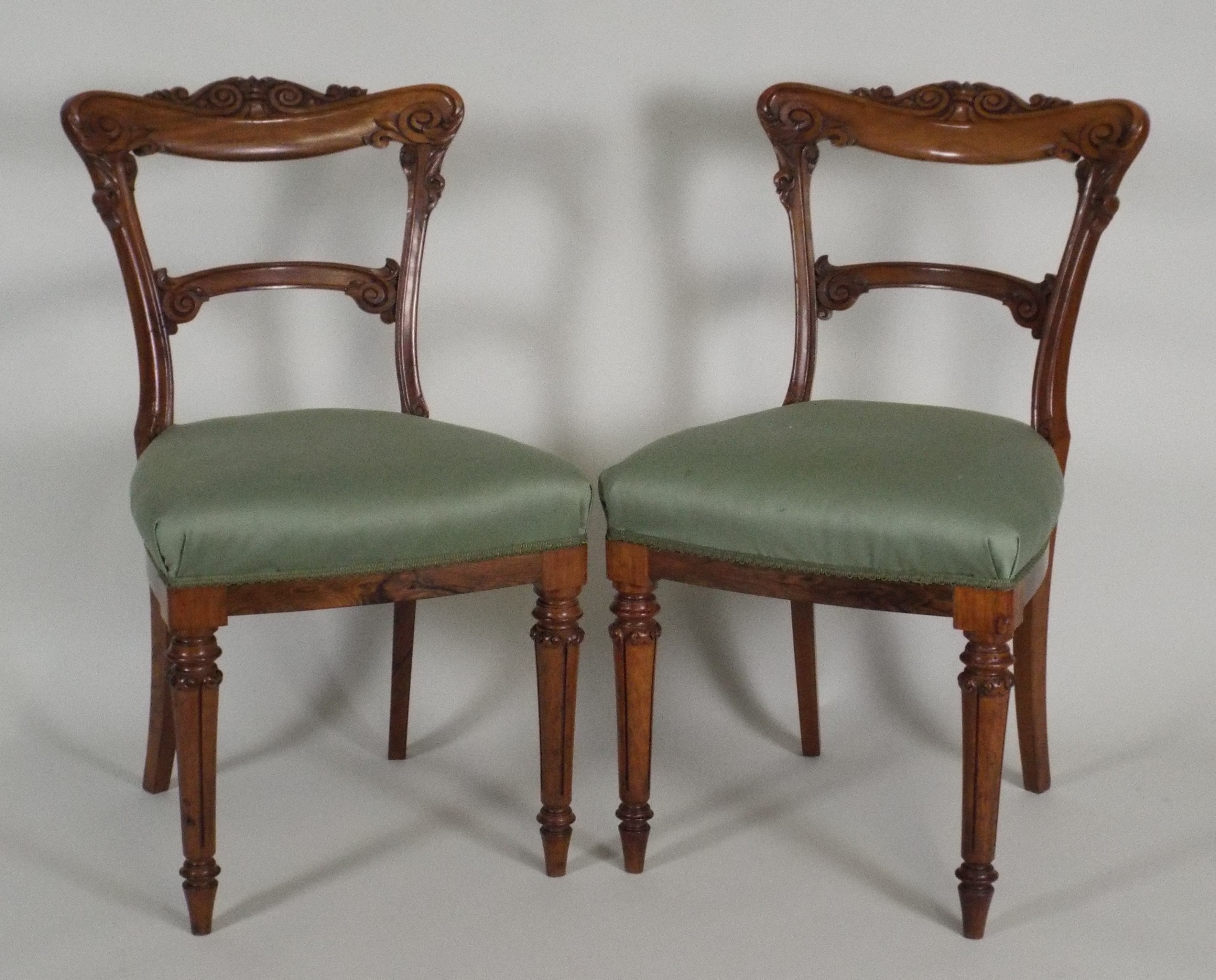 A set of six early Victorian rosewood and faux grained dining chairs, each with a scroll carved top