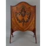 A late Victorian satinwood polychrome decorated shield shaped fire screen, the centre with ribbon
