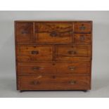 A 19th century teak campaign style desk/chest, the rectangular top with rounded edges over a central