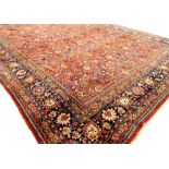 A Tabriz blue and red ground carpet with stylized all-over design to the centre within a triple