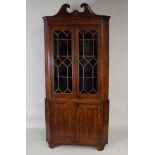 An early 19th century mahogany floor standing, straight fronted corner cabinet, the swan neck