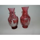 A pair of cranberry glass Mary Gregory style vases,