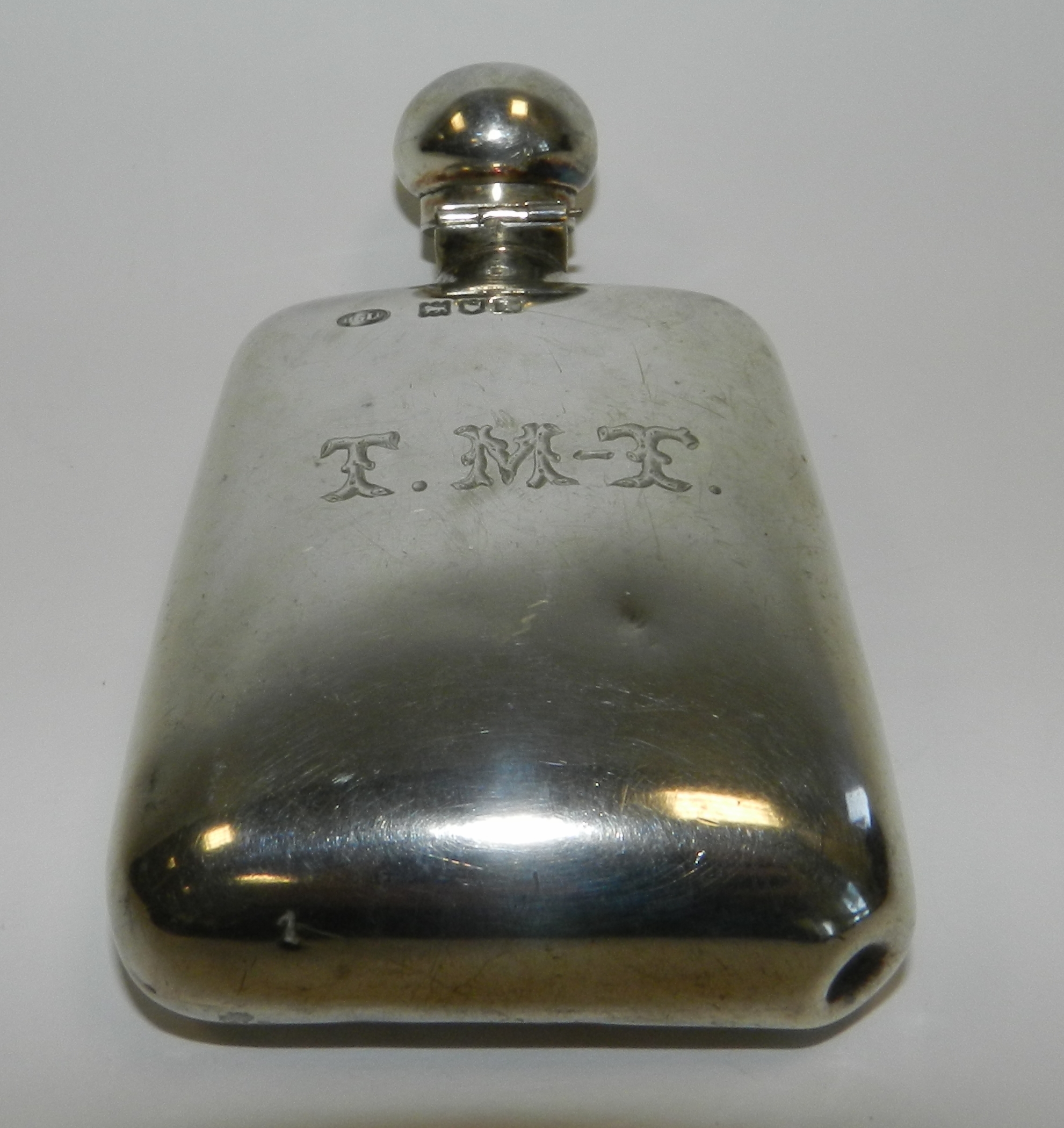 A silver hip flask hallmarked London with engraved initials 'T M T'