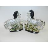 A pair of Staffordshire models of zebra on black oval bases